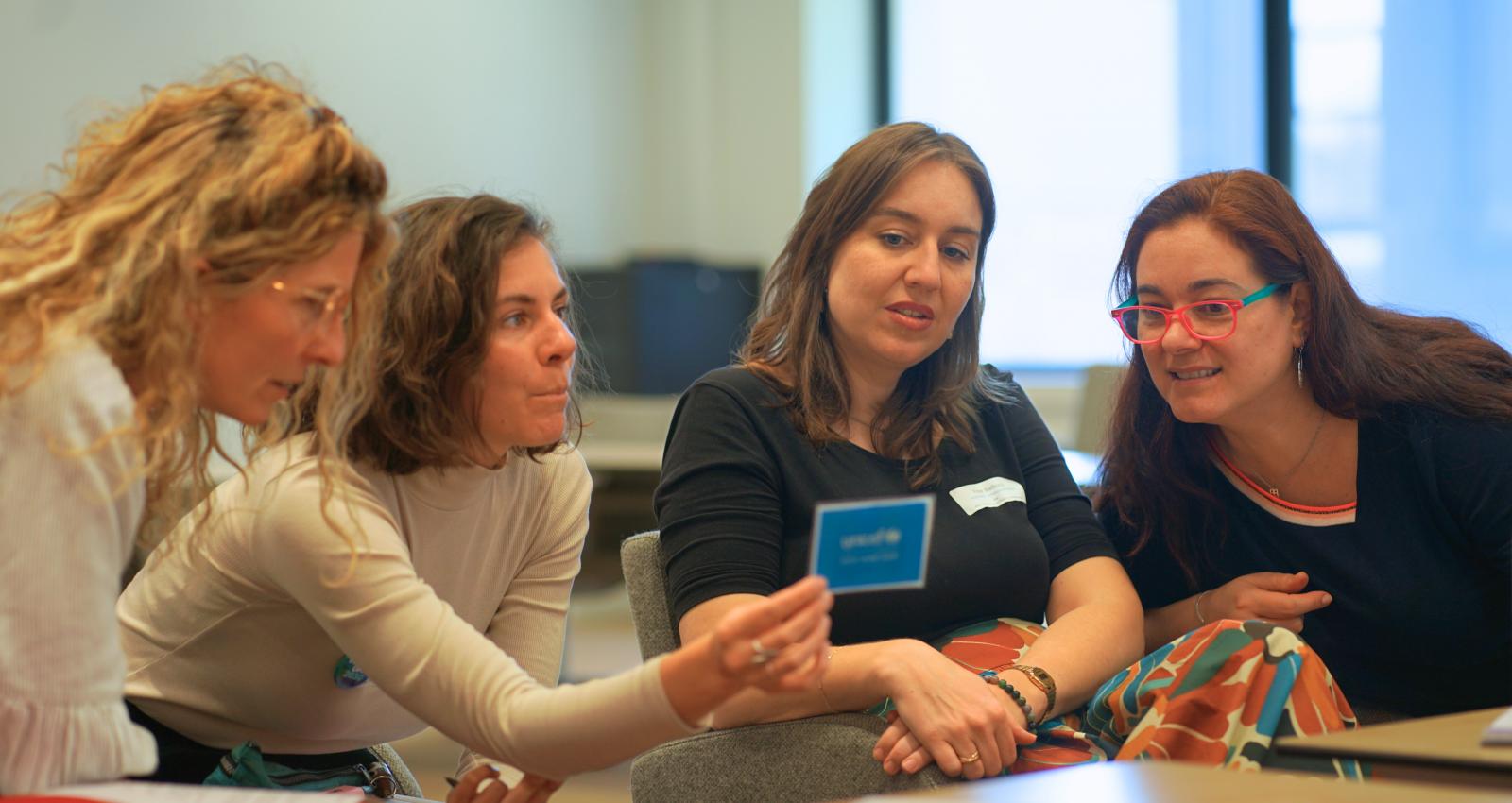 a group of women reading a card during a workshop