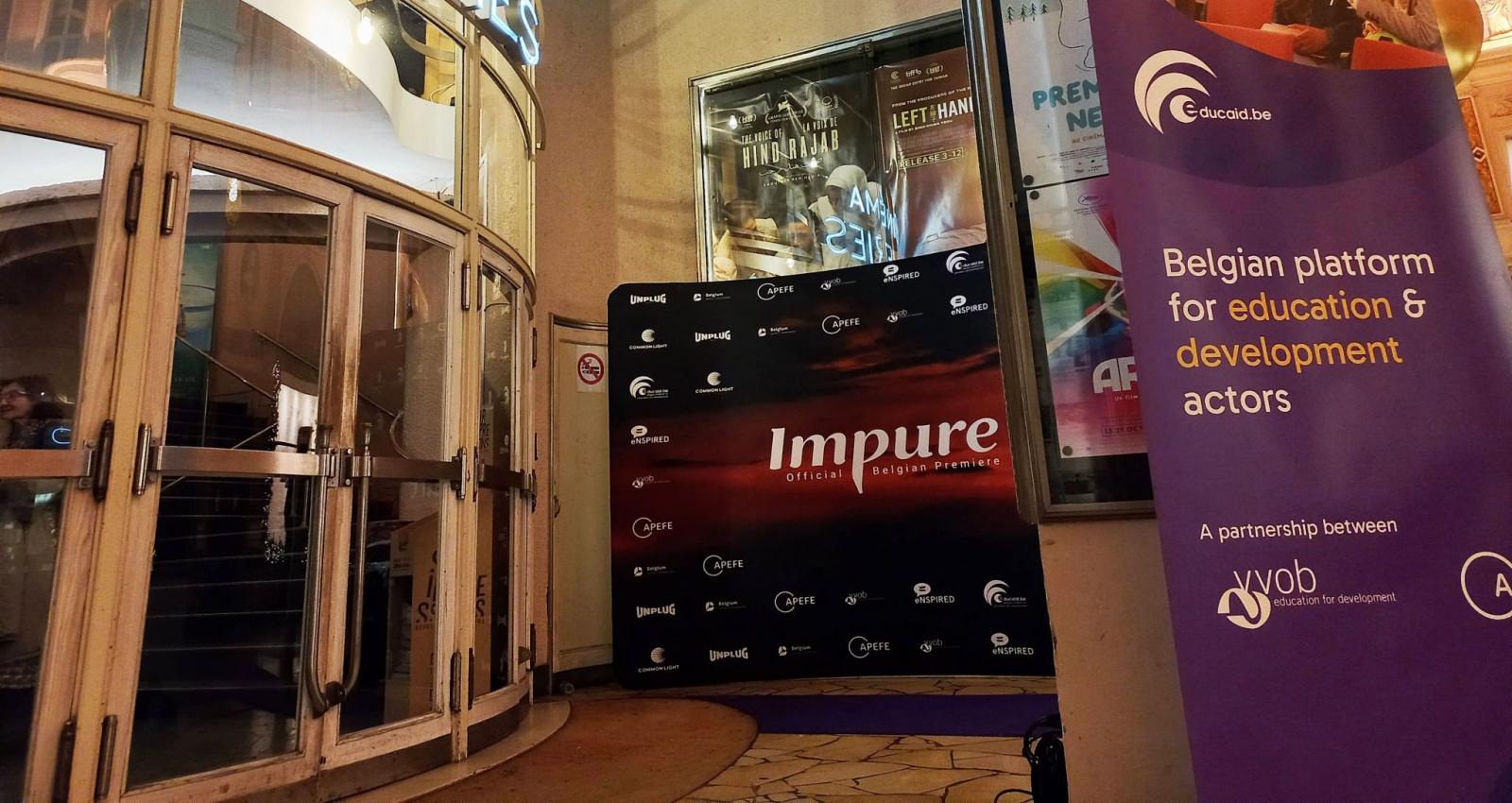 A cinema entrance with a photo wall from Impure and a purple banner with Educaid.be