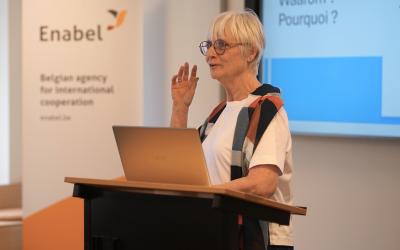 An older woman presenting at a conference, engaging the audience with her insights and expertise.