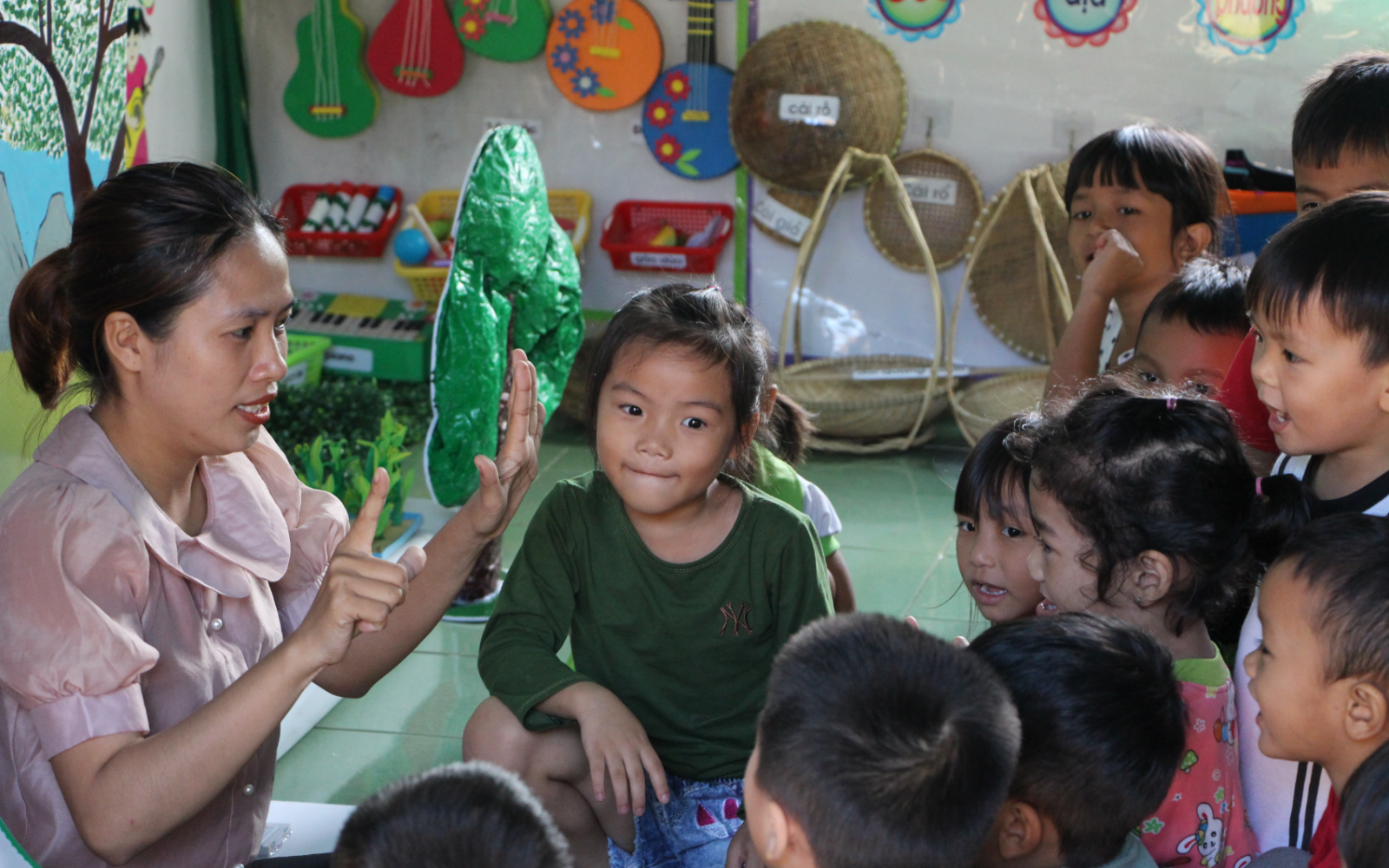 A group of children sitting around a teacher in the classroom