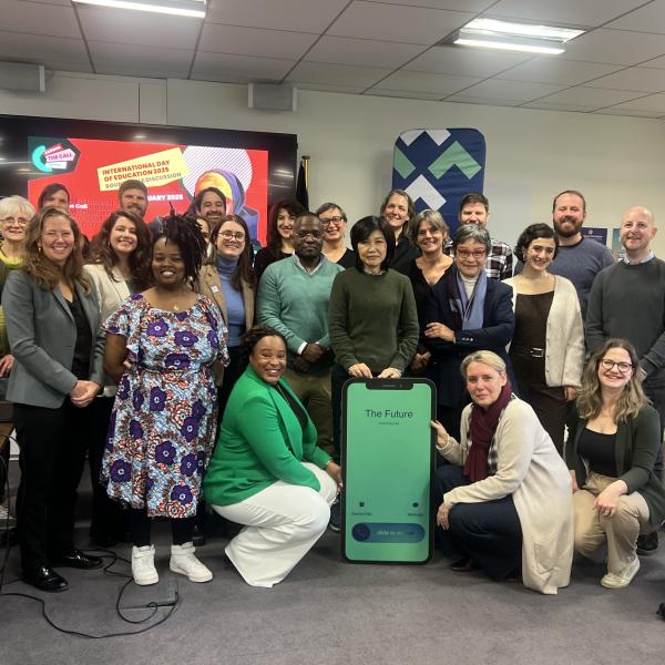 a group of people posing with a cardboard phone