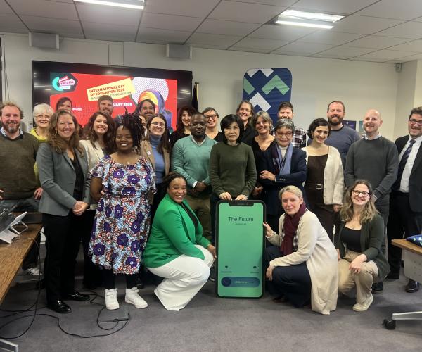 a group of people posing with a cardboard phone