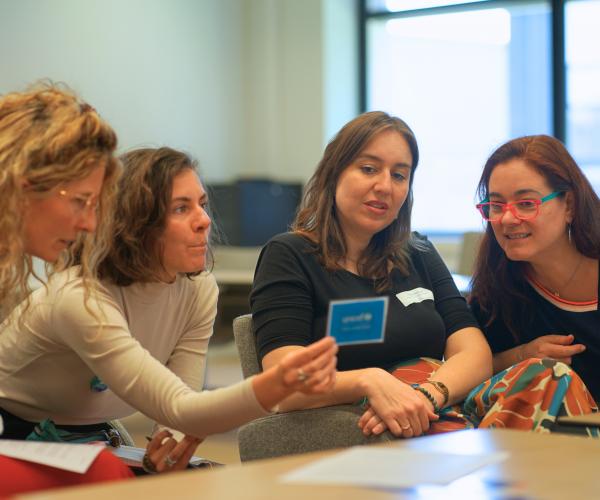a group of women reading a card during a workshop